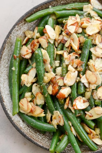 Garlic Butter Green Beans are a family favorite! Tender green beans are tossed in a rich butter sauce and topped toasted almonds, each serving is just under 4 net carbs.