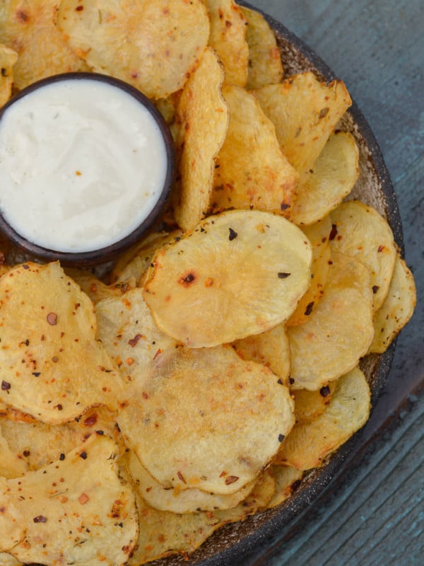 Learn how to make homemade potato chips that are baked instead of fried! This recipe only requires three ingredients and takes less than 20 minutes!