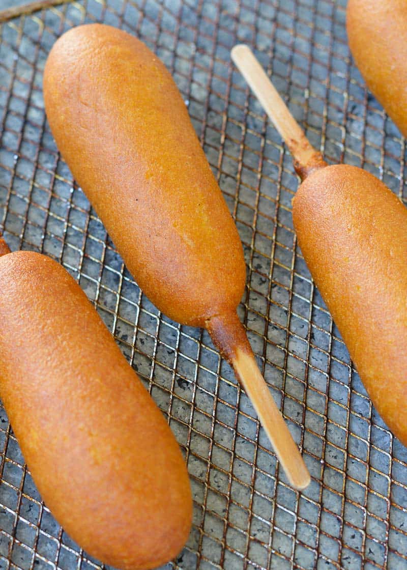 several crispy corn dogs on an air fryer rack