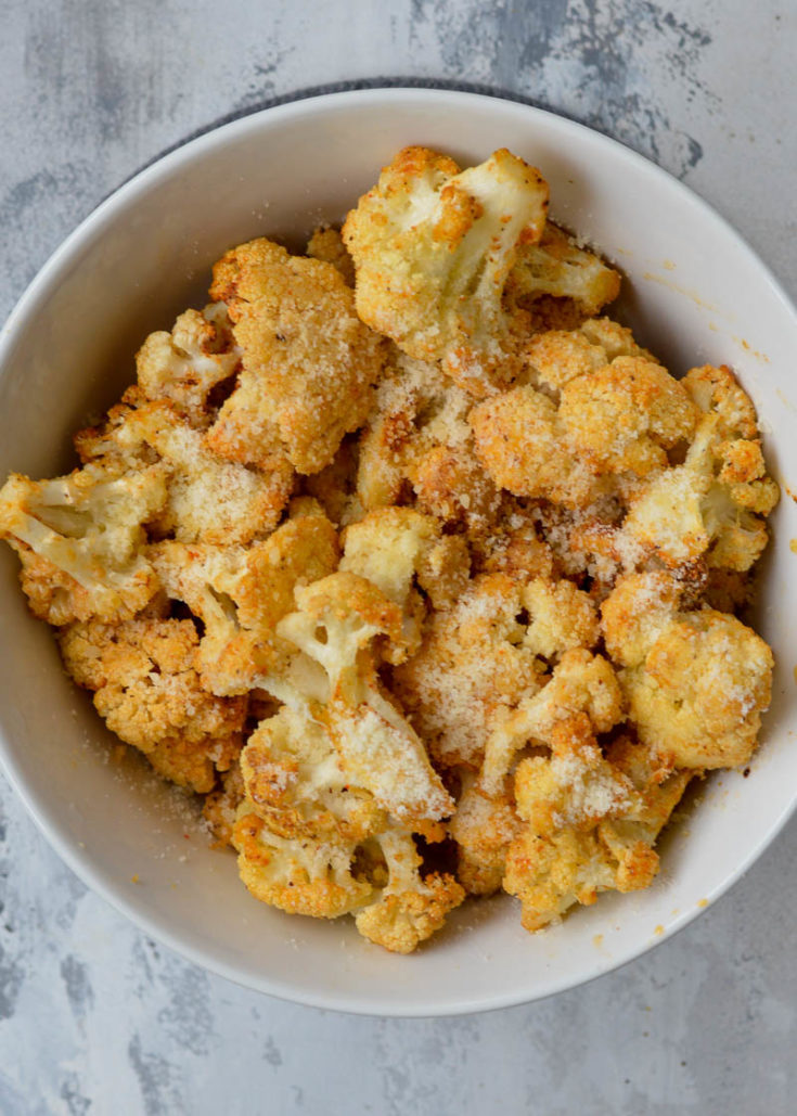This delicious Air Fryer Parmesan Cauliflower is tossed in a delicious garlic parmesan sauce and cooked to crispy perfection! Just 4 net carbs for a full cup of this buttery side dish.