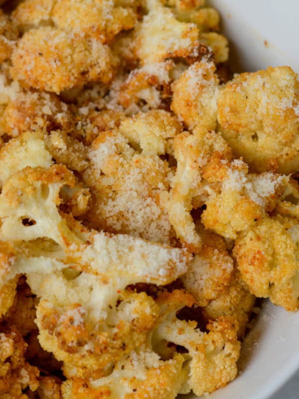 This delicious Air Fryer Parmesan Cauliflower is tossed in a delicious garlic parmesan sauce and cooked to crispy perfection! Just 4 net carbs for a full cup of this buttery side dish.