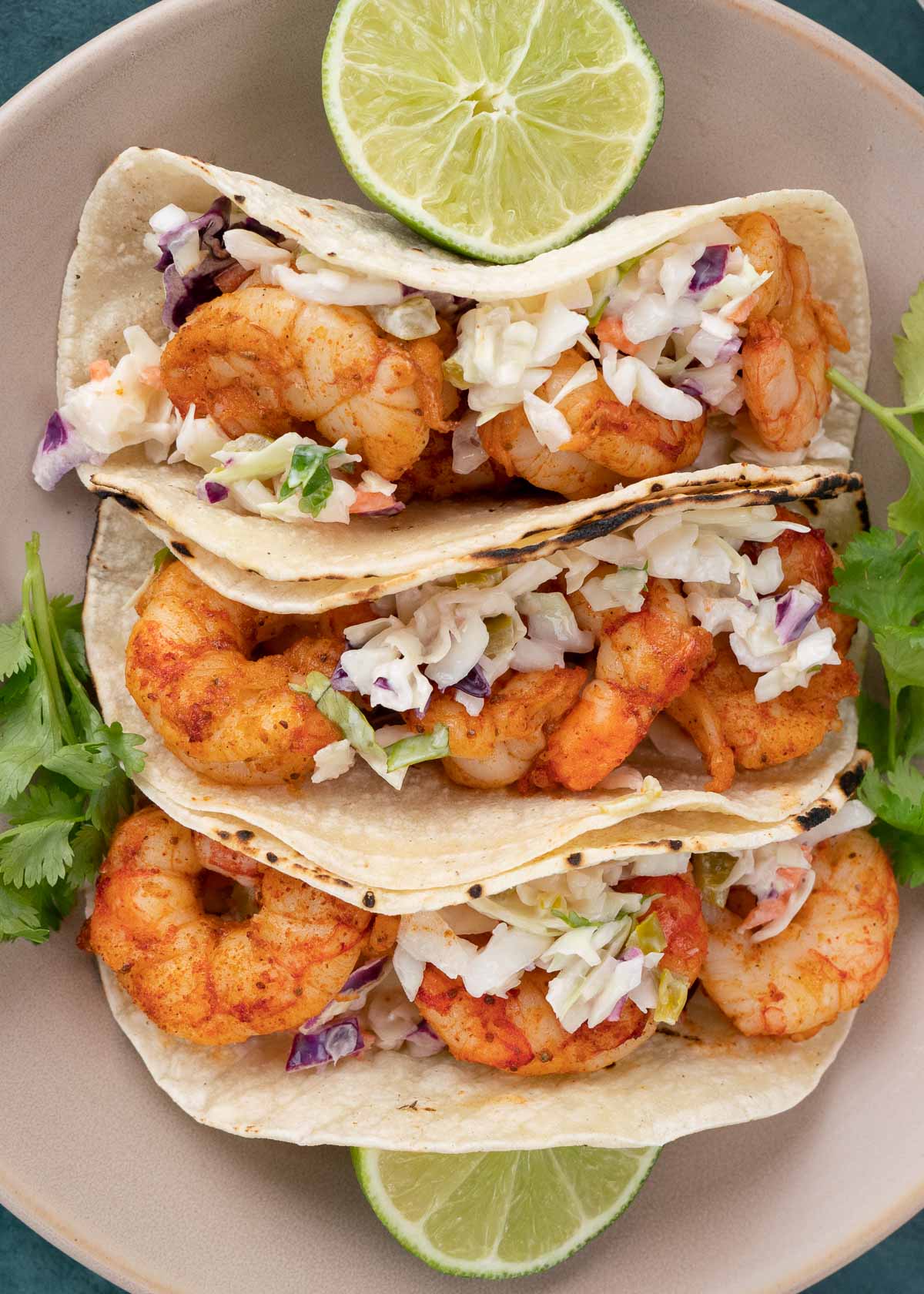 shrimp tacos with slaw on plate with limes