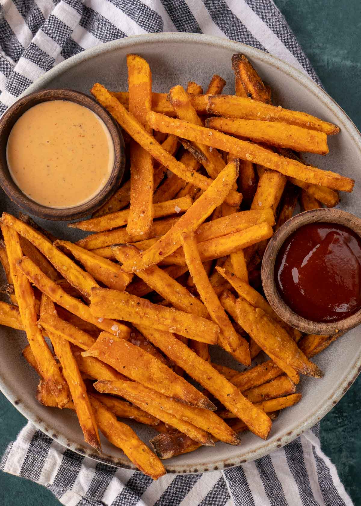 sweet potato fries on a white plate with dipping sauce