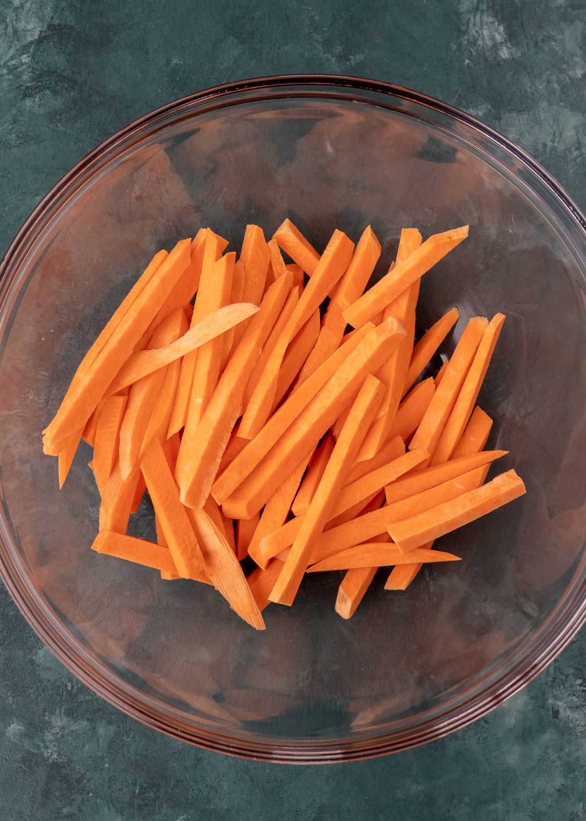 sweet potato fries in a clear mixing bowl