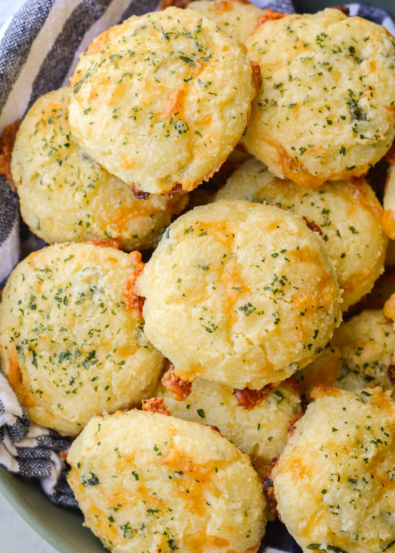 These Keto Three Cheese Biscuits are perfectly soft and fluffy! Each low carb biscuit is loaded with sharp cheddar, mozzarella and fresh basil for just 2 net carbs each!