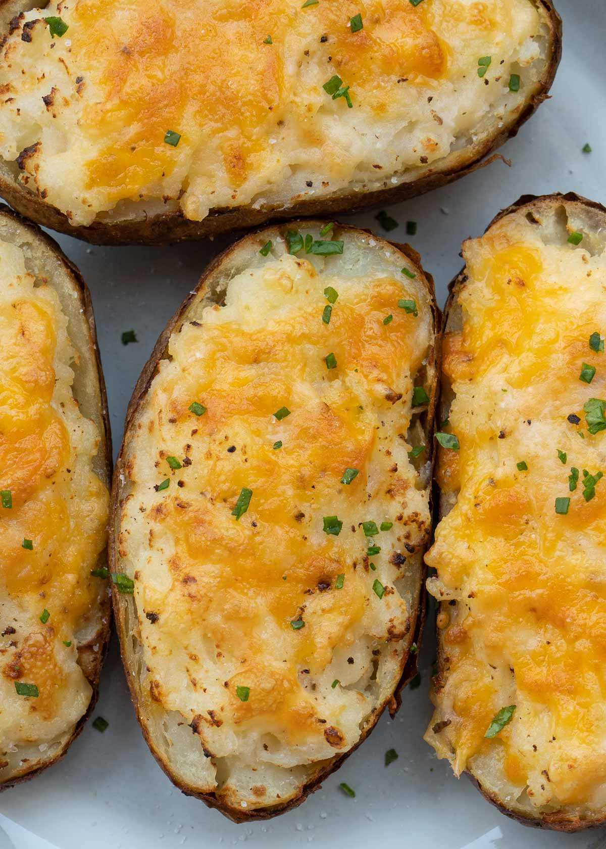 These Air Fryer Twice Baked Potatoes are the perfect side dish or appetizer! Get that cheesy center and ultra-crispy potato skin quickly with this easy recipe.
