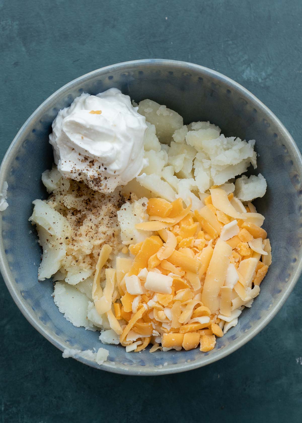 mix together sour cream, milk, scooped potato, melted butter, and 1/4 cup cheese