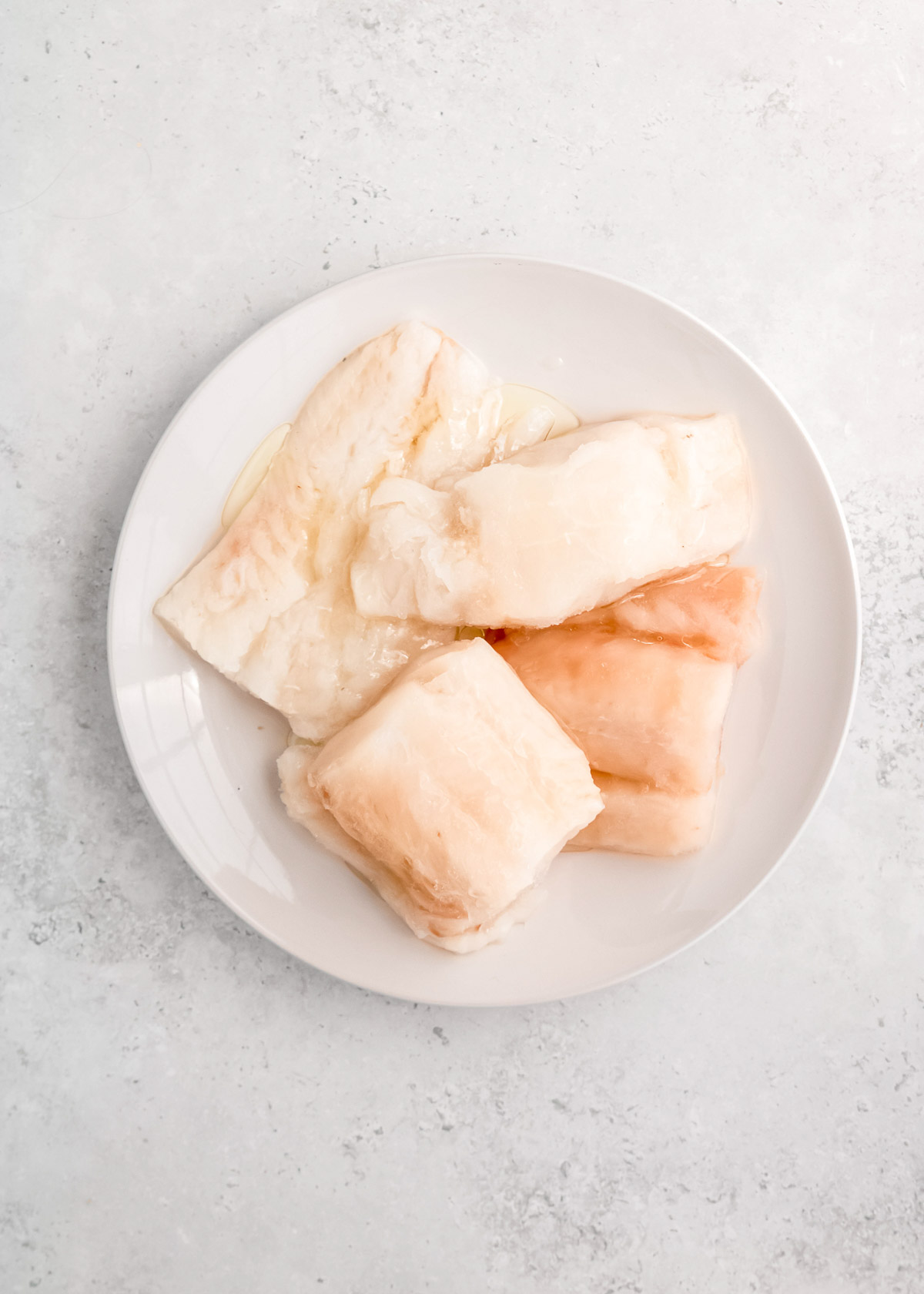 raw fish filets on white plate