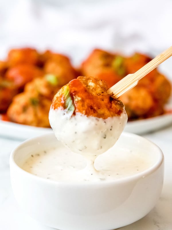 buffalo chicken meatball being dipped in ranch