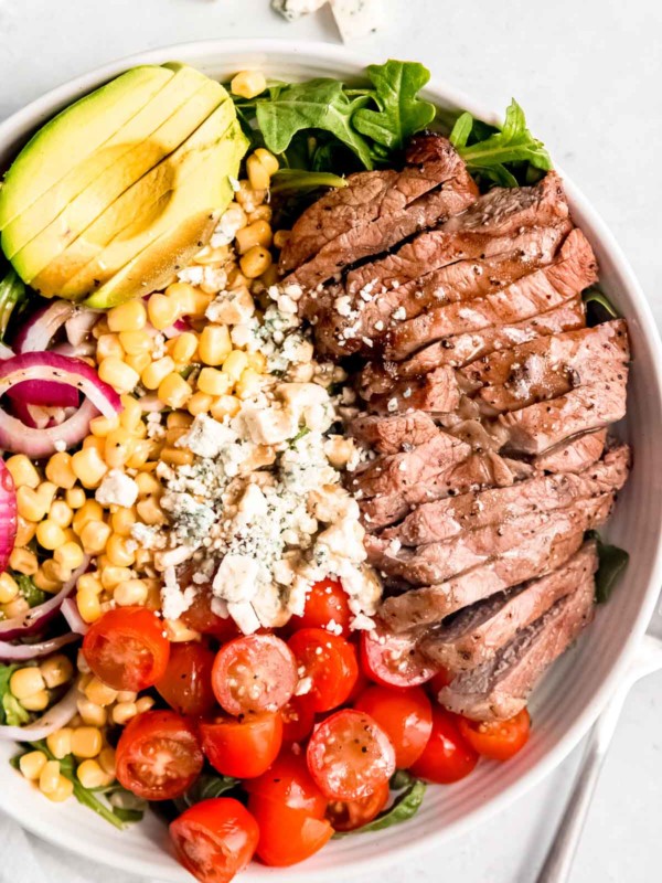 Prepared steak salad in a white plate on a white table