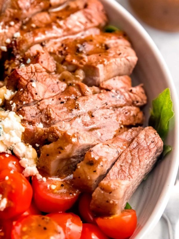 steak salad in a white bowl