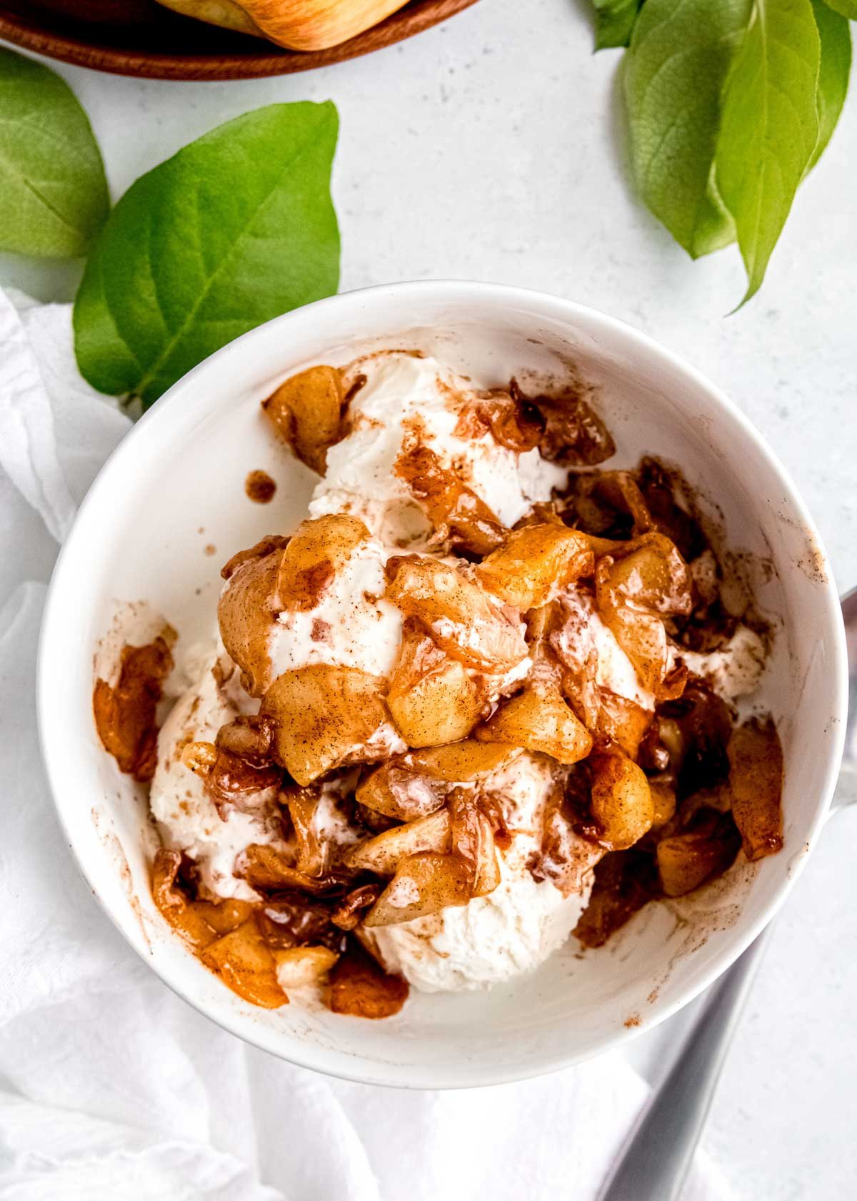 air fried apples on ice cream in a white bowl