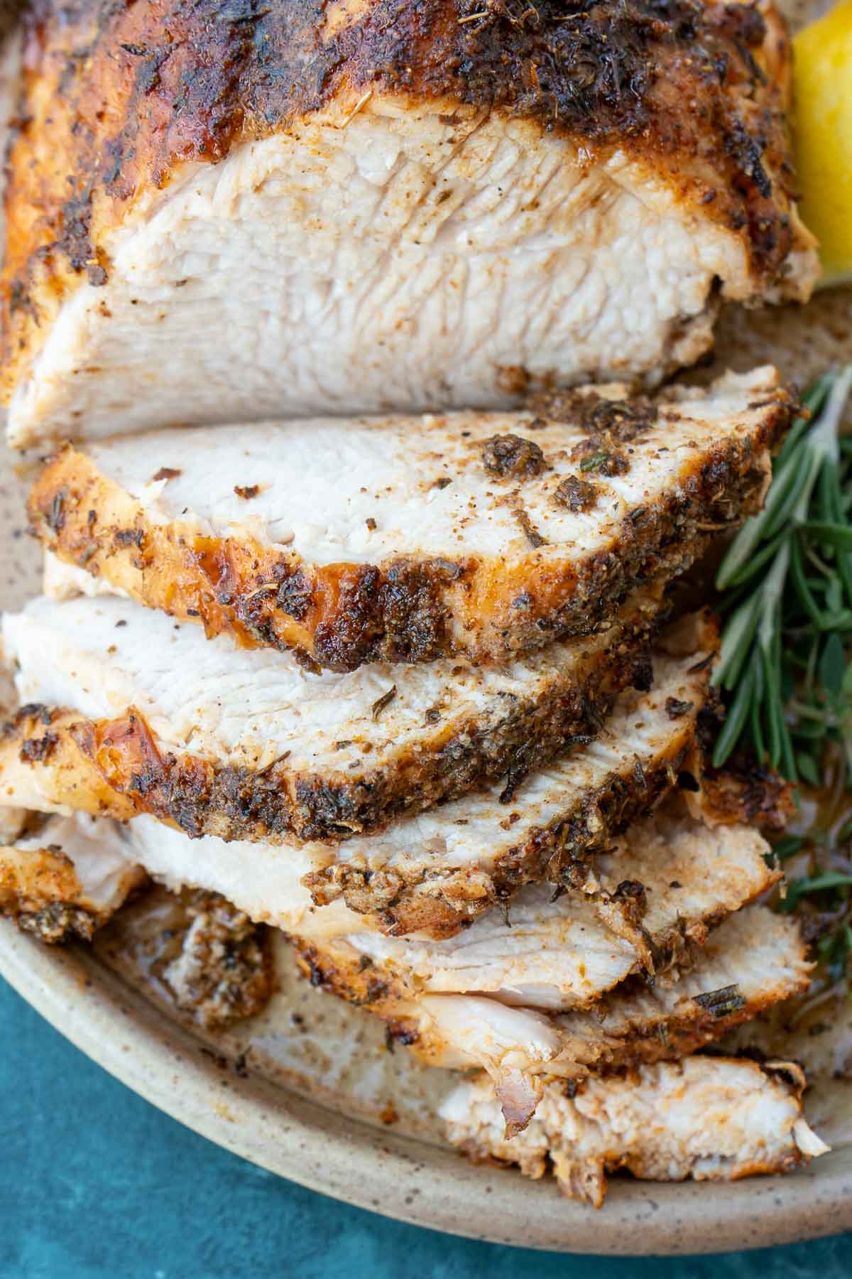 a sliced, seasoned turkey breast on a plate