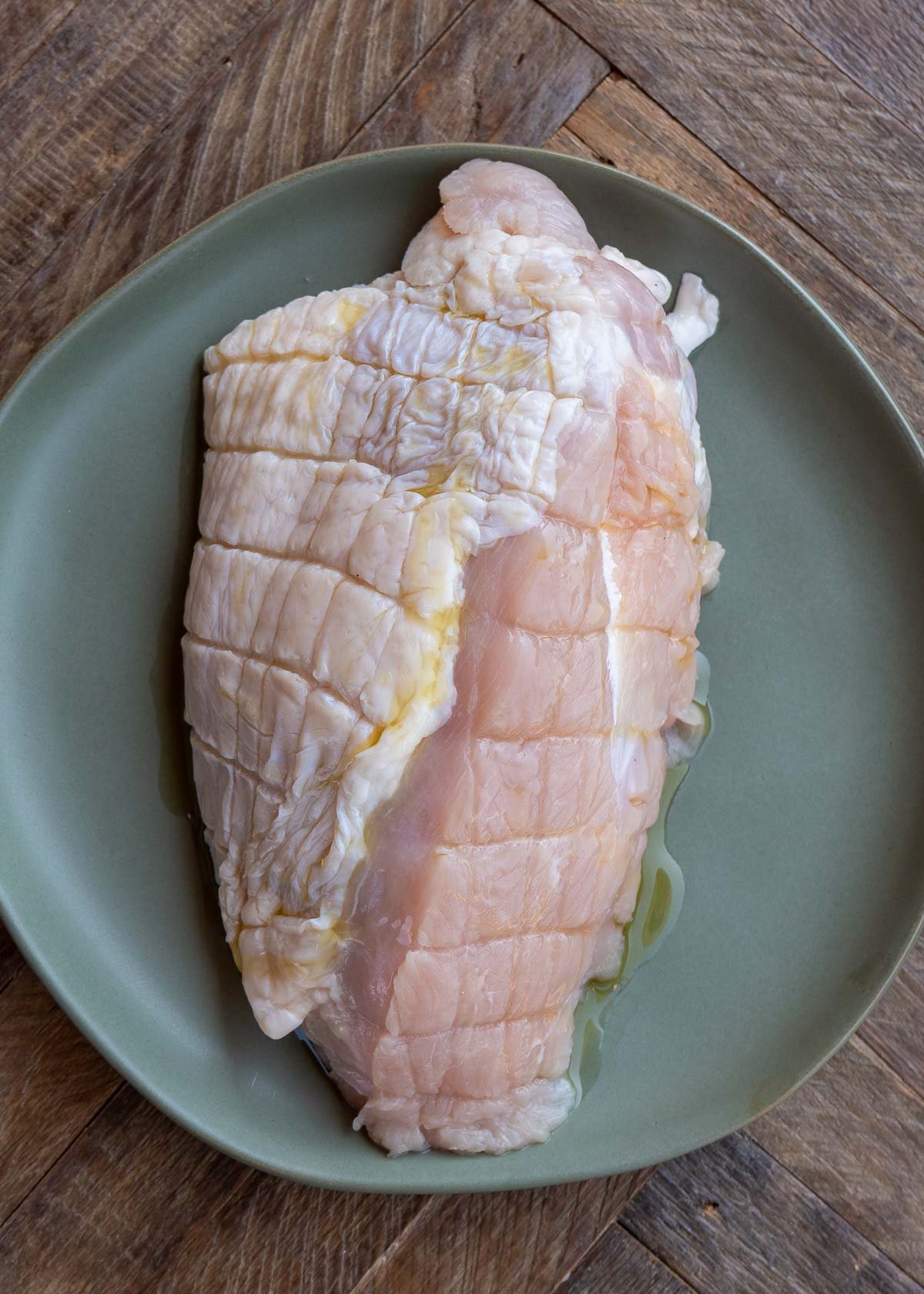 a turkey breast on a plate with olive oil