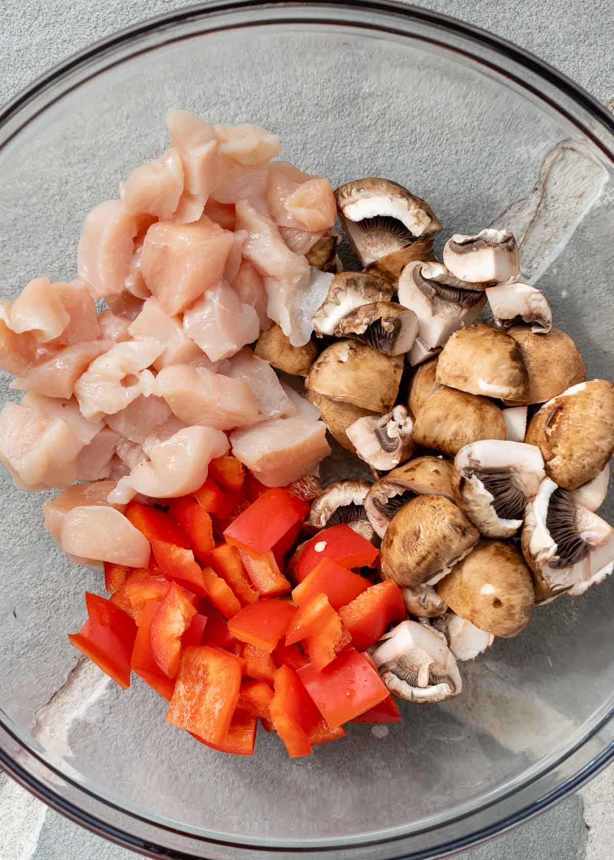 bite-size chicken, mushrooms, and red peppers in a glass bowl