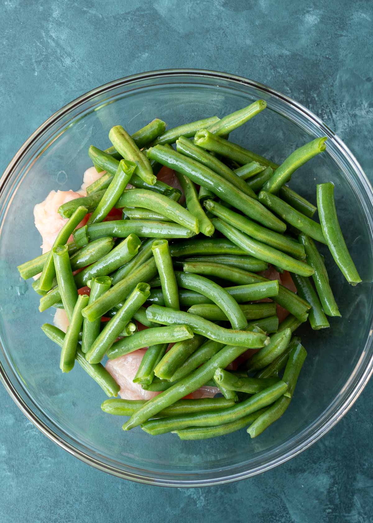 green beans and chicken pieces in a glass bowl