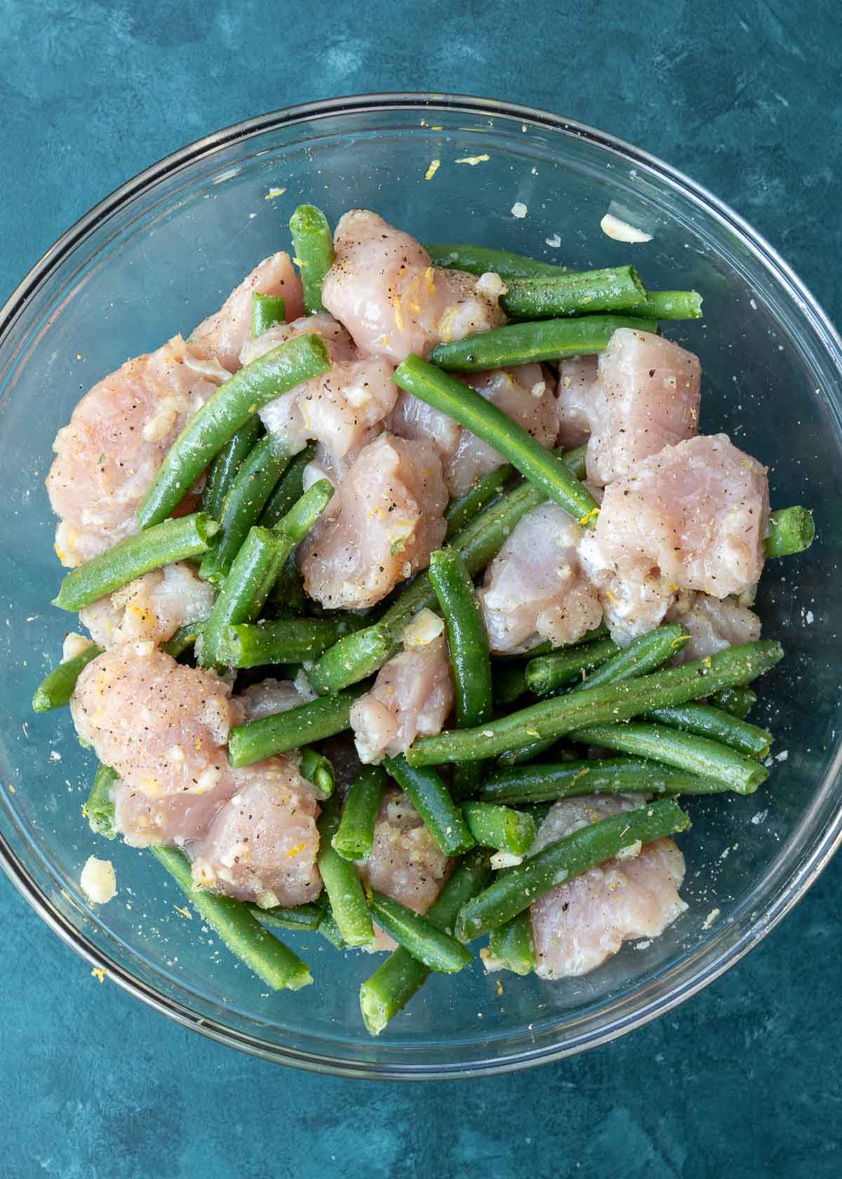 seasoned chicken and green beans in a glass bowl
