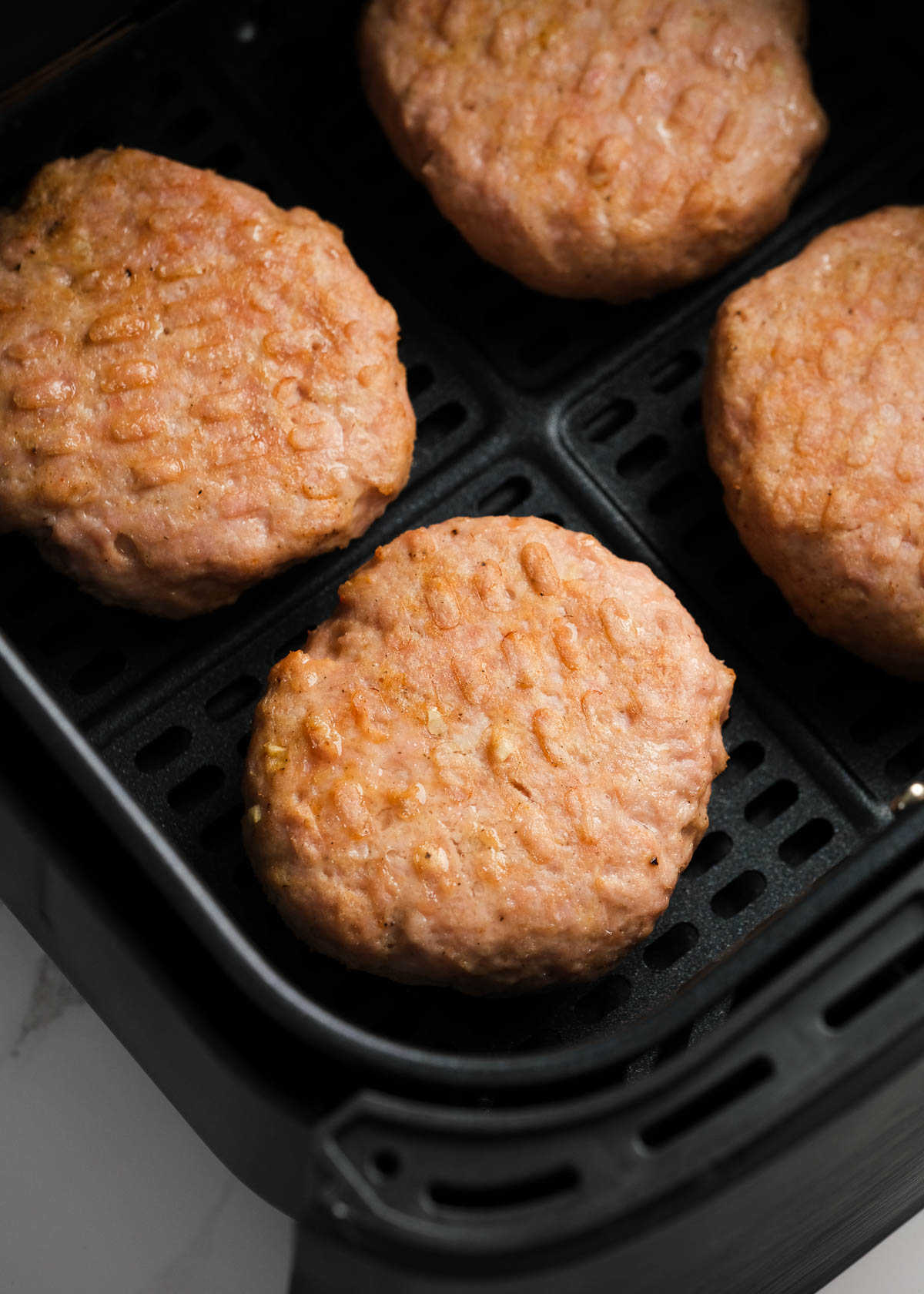 cooked turkey burgers in the air fryer basket