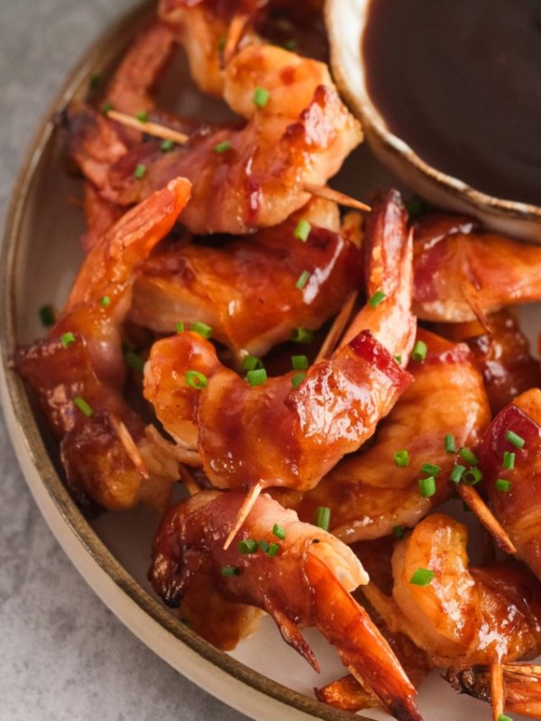 closeup shot of bacon-wrapped shrimp with bbq sauce and chives
