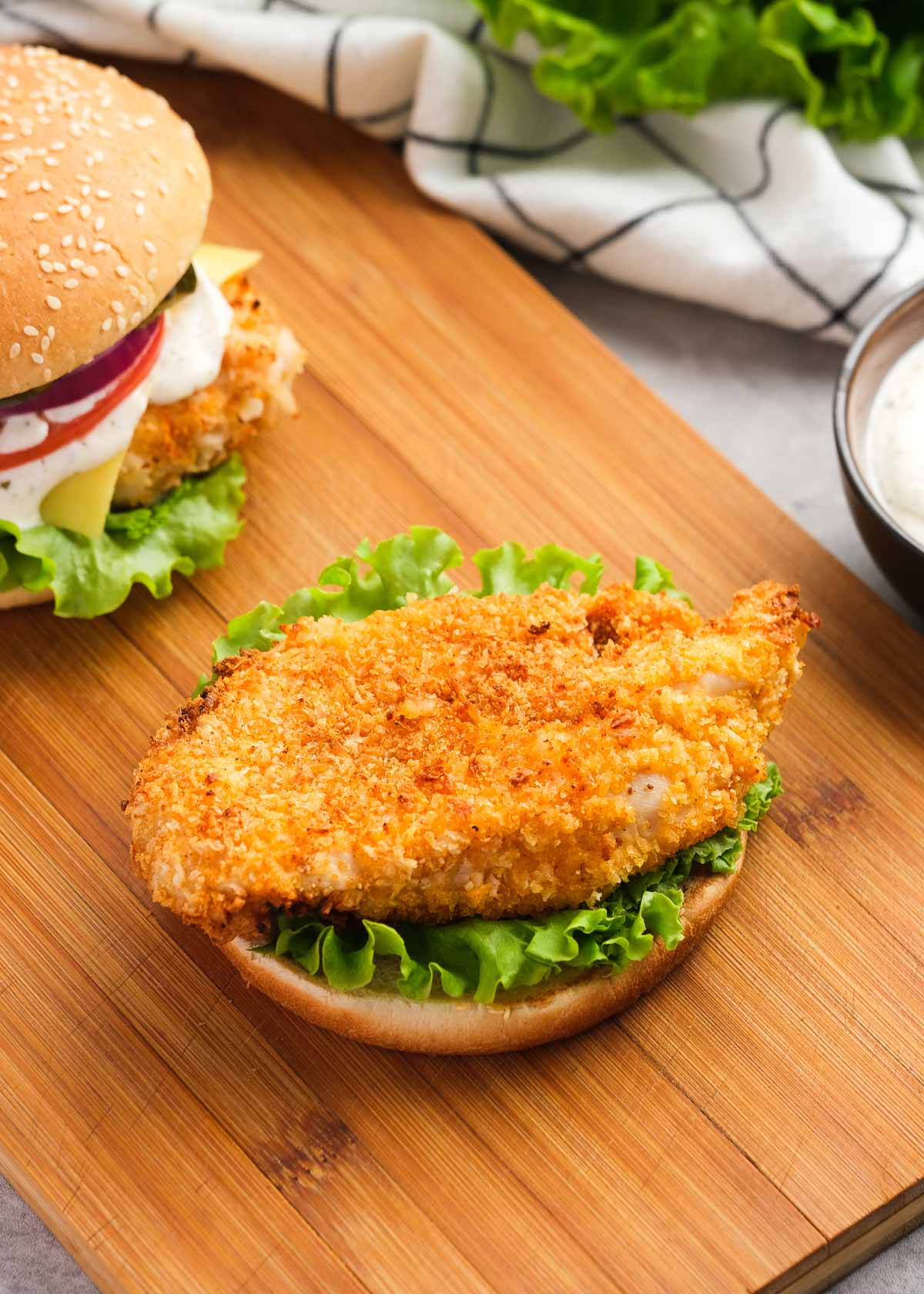 a crispy chicken fillet lying on a bed of lettuce and bun, waiting for other chicken sandwich toppings.