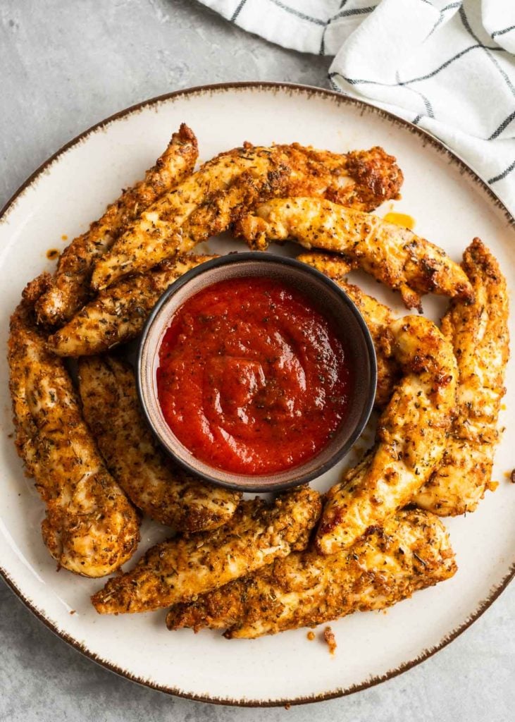 chicken tenders on a plate with dipping sauce