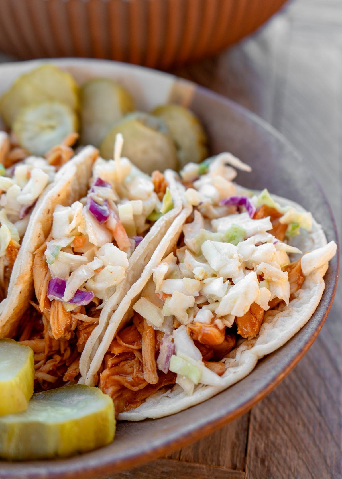 closeup of bbq chicken tacos on low carb tortillas topped with easy coleslaw recipe