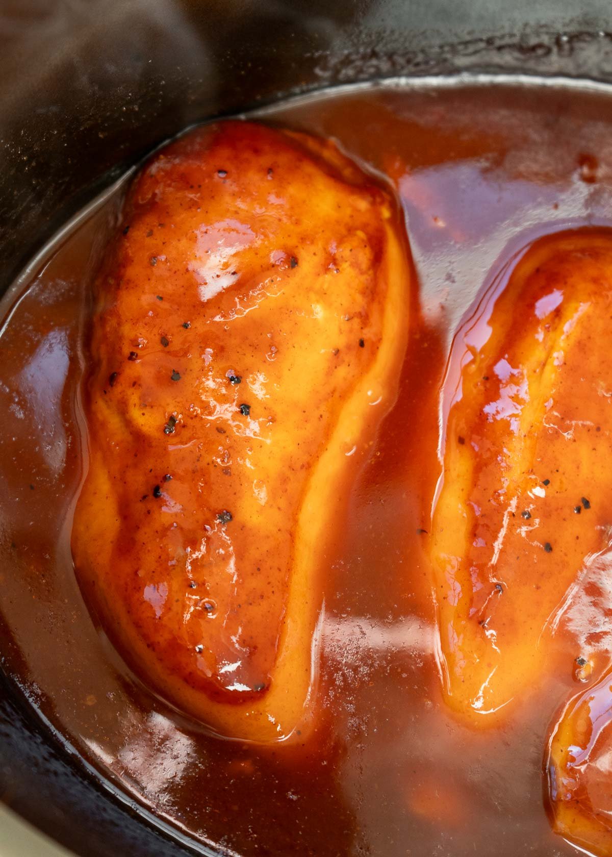 chicken breasts covered in low-carb bbq sauce in the slow cooker