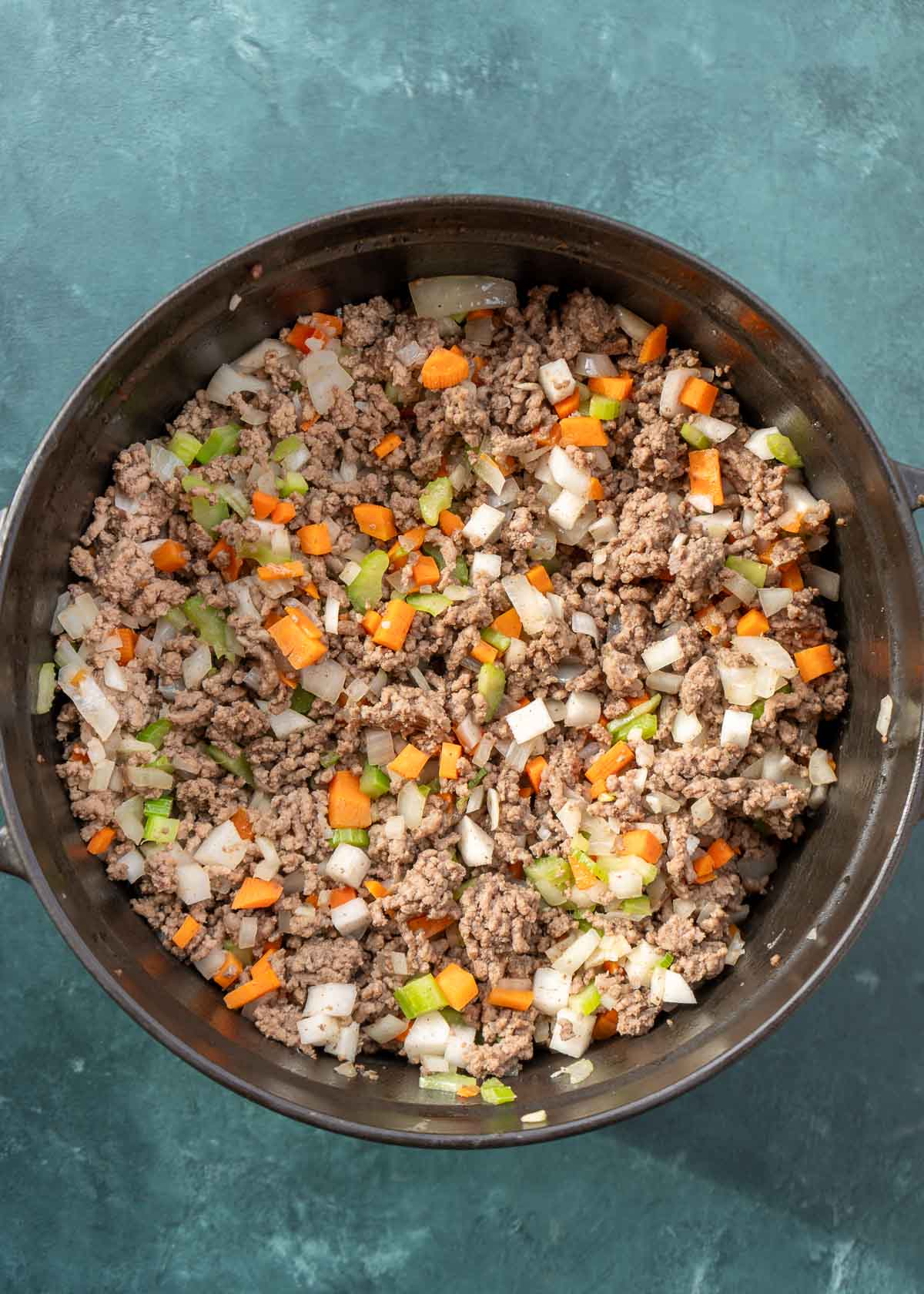 ground meat and veggies in cast iron dutch oven