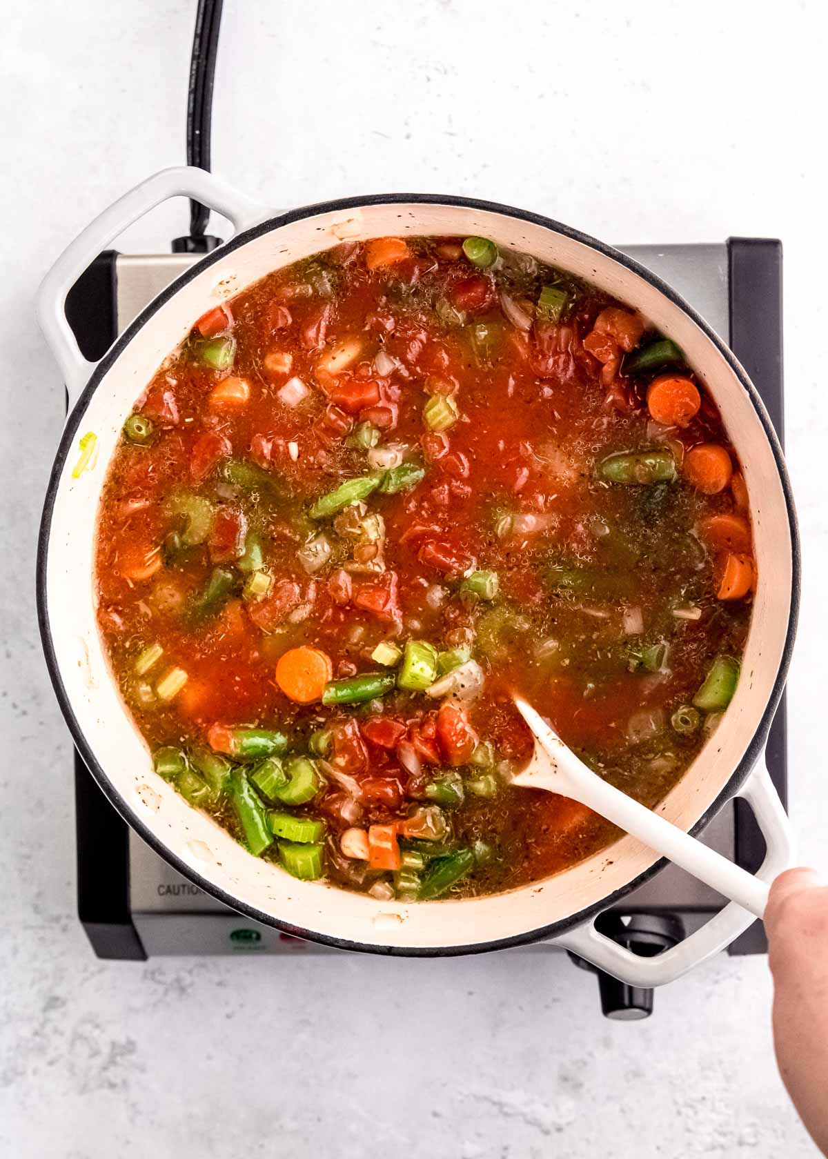 broth, veggies, and beans mixed together in a dutch oven
