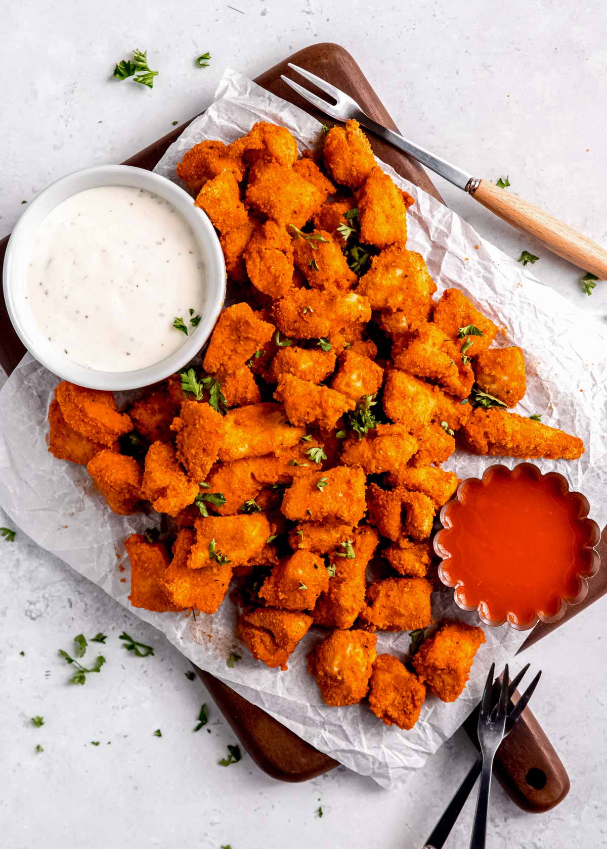 wide view of buffalo chicken bites and dipping sauce on white table
