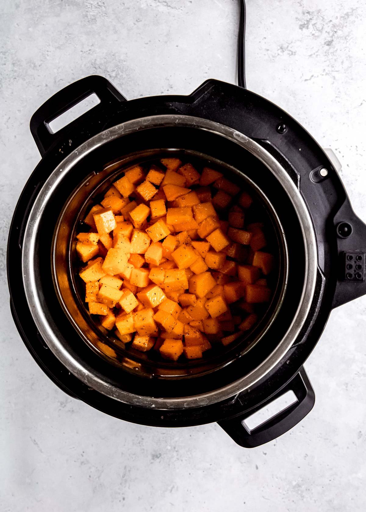 raw cubed butternut squash in an air fryer 