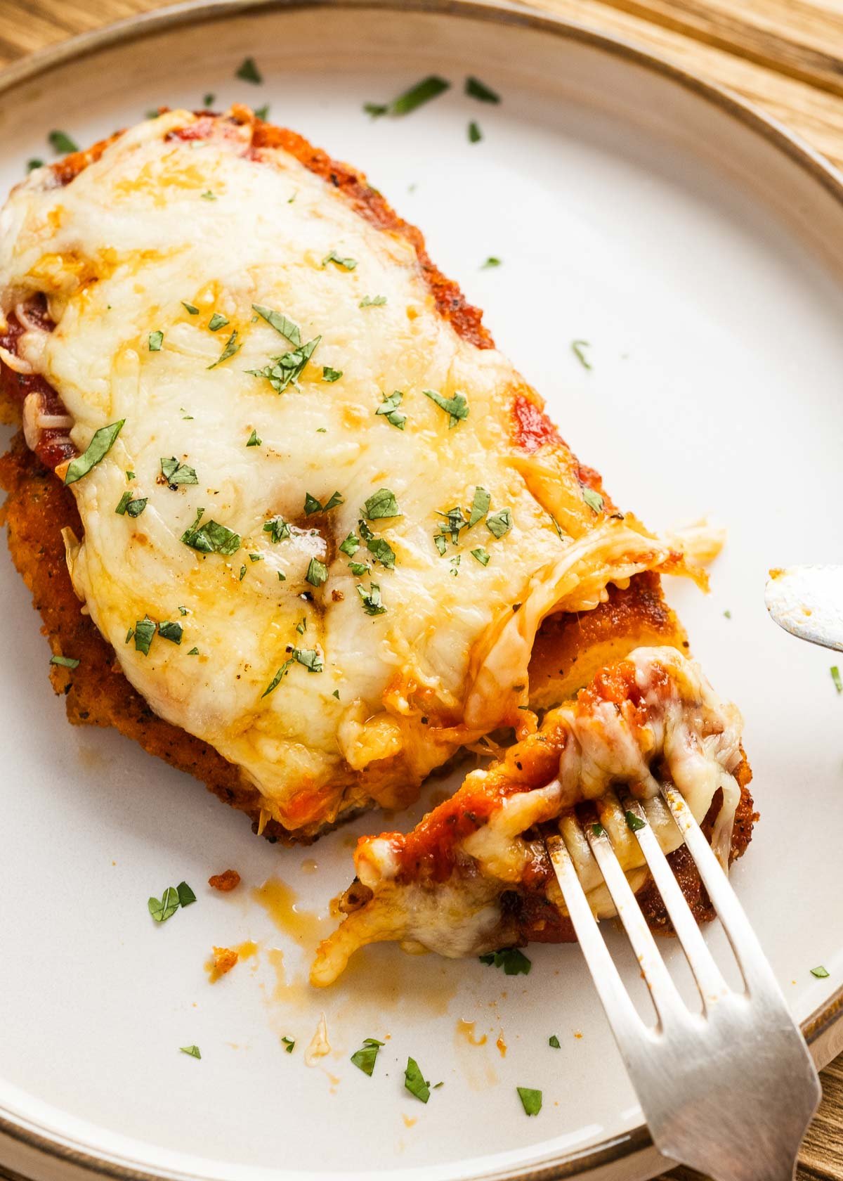 chicken parmesan on a plate with a fork