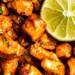 close up image of air fryer cilantro lime chicken bites and lime wedge