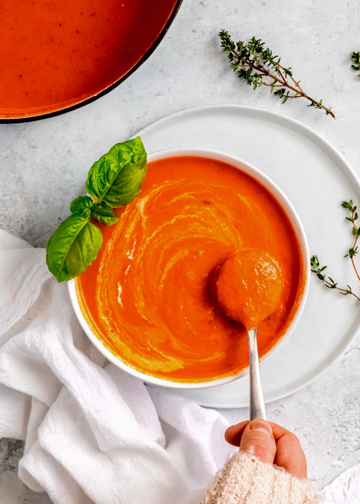 a spoon full of roasted red pepper and tomato soup