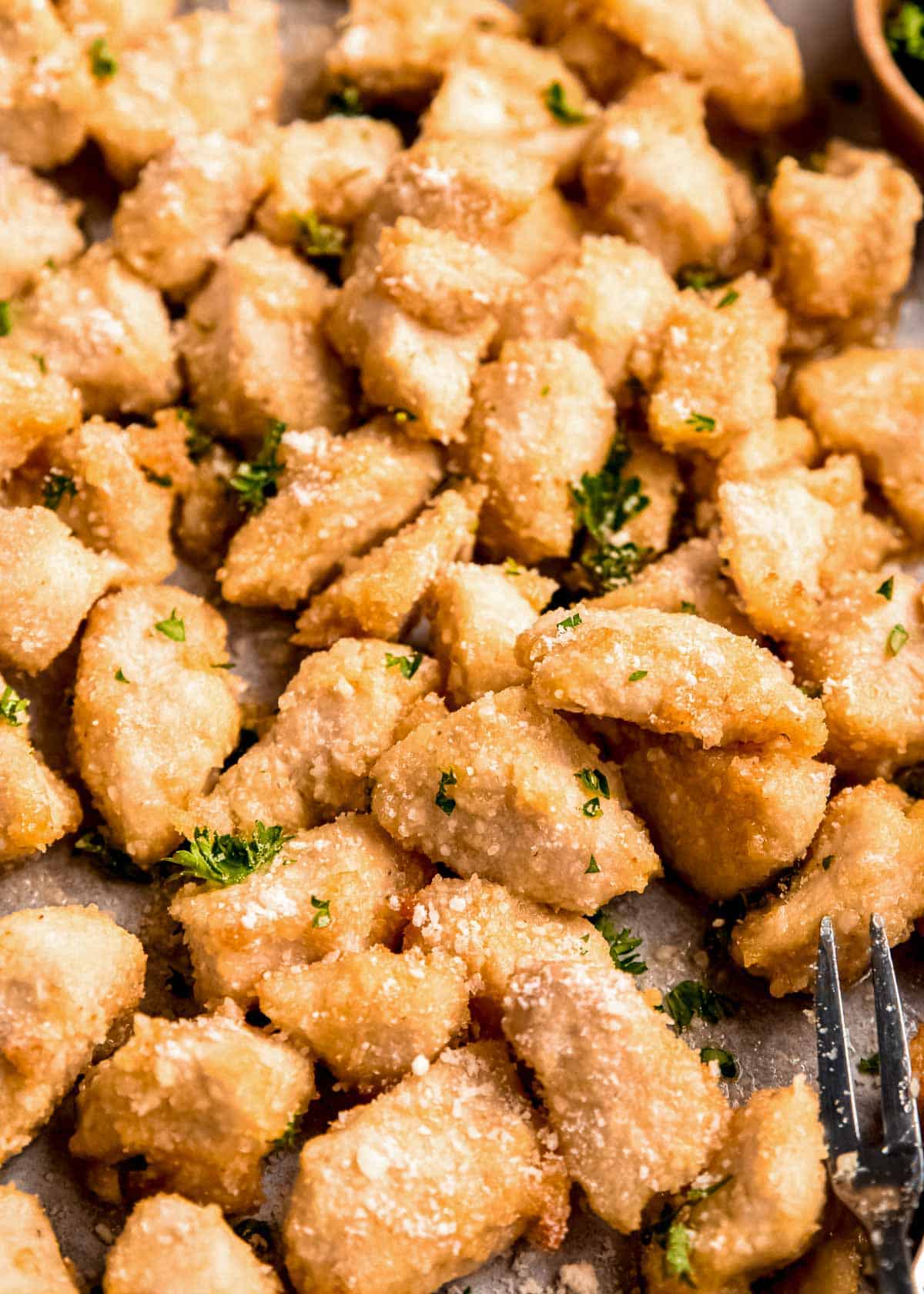 closeup image showing juicy chicken bites coated in parmesan and spices