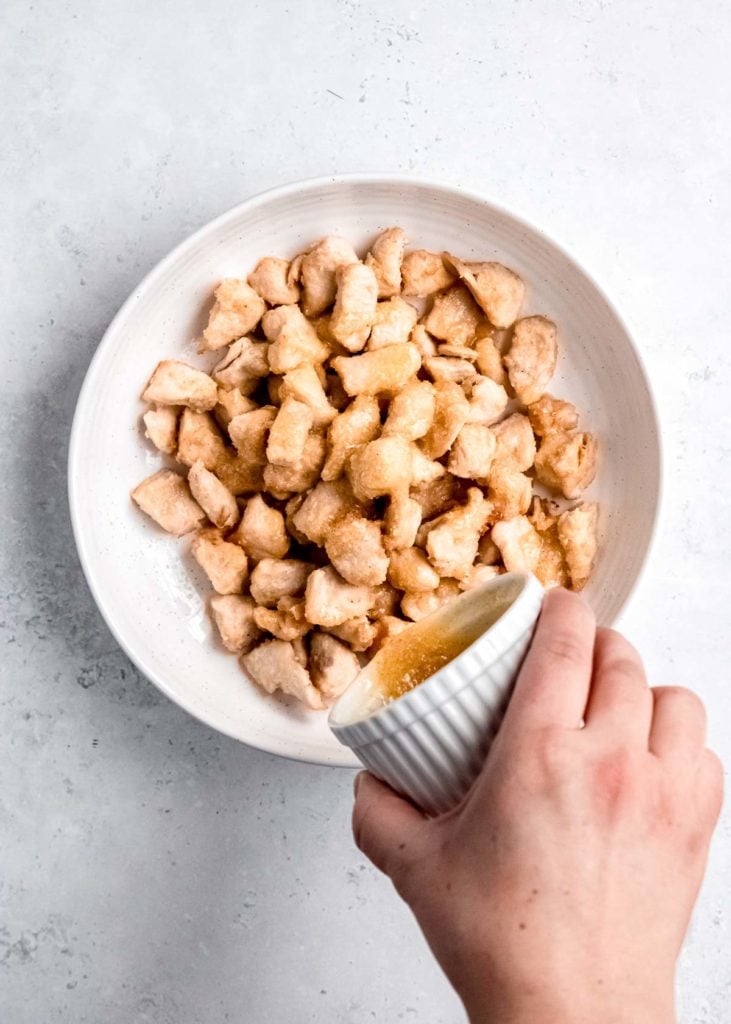 garlic butter sauce being added to chicken bites