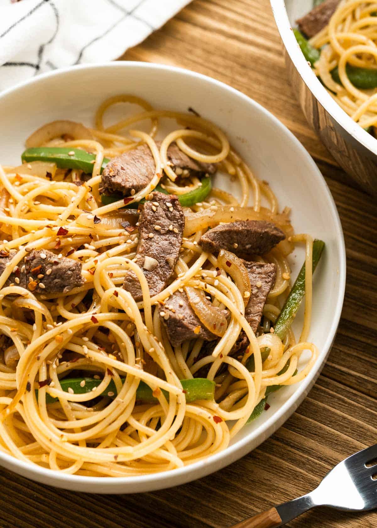 overhead shot of sesame noodles with beef and peppers