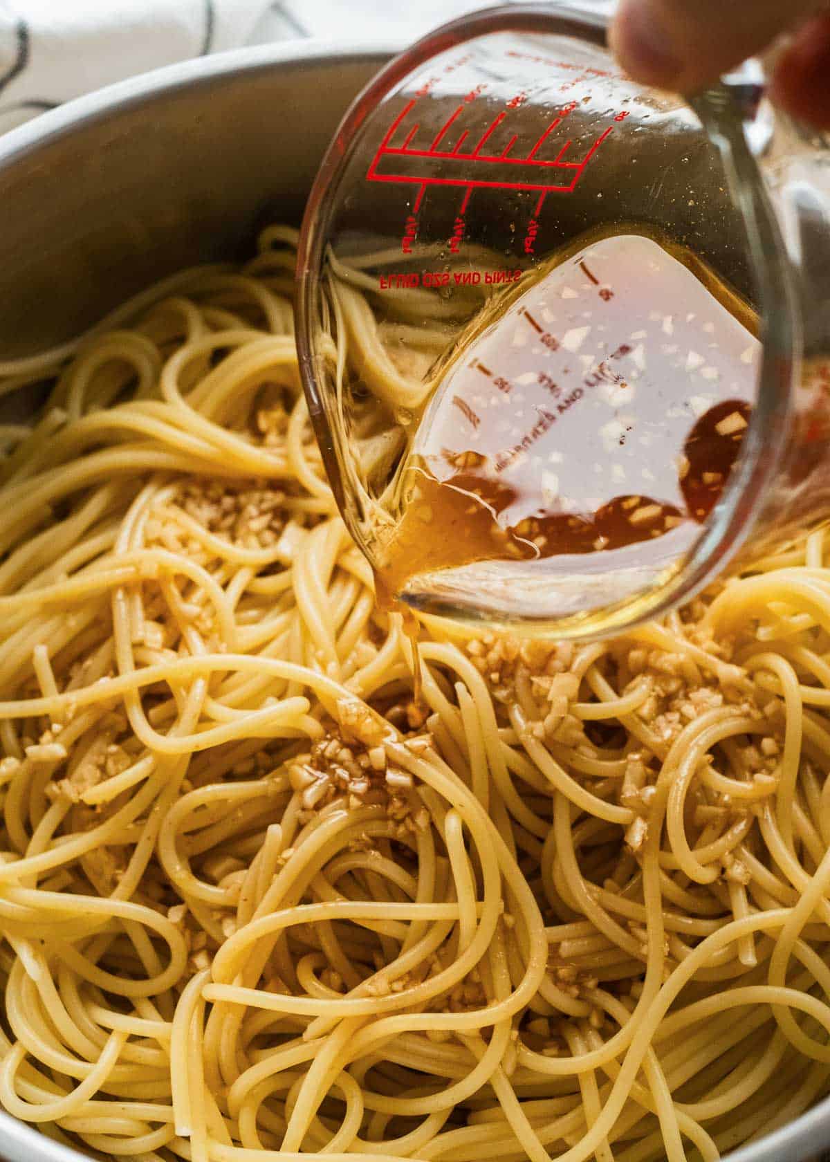 sauce being poured over sesame noodles