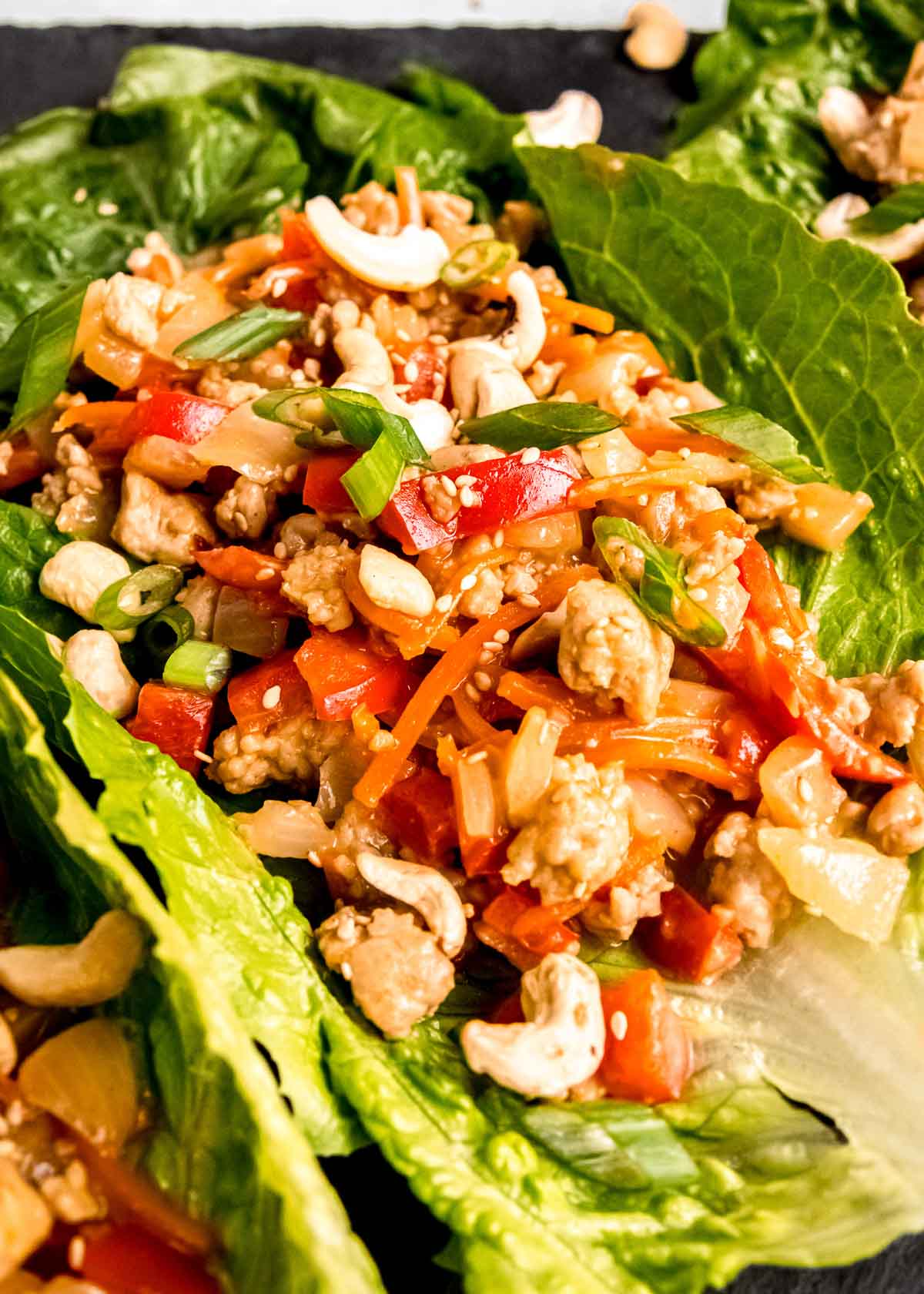 closeup shot of juicy chicken lettuce wraps with peanut sauce