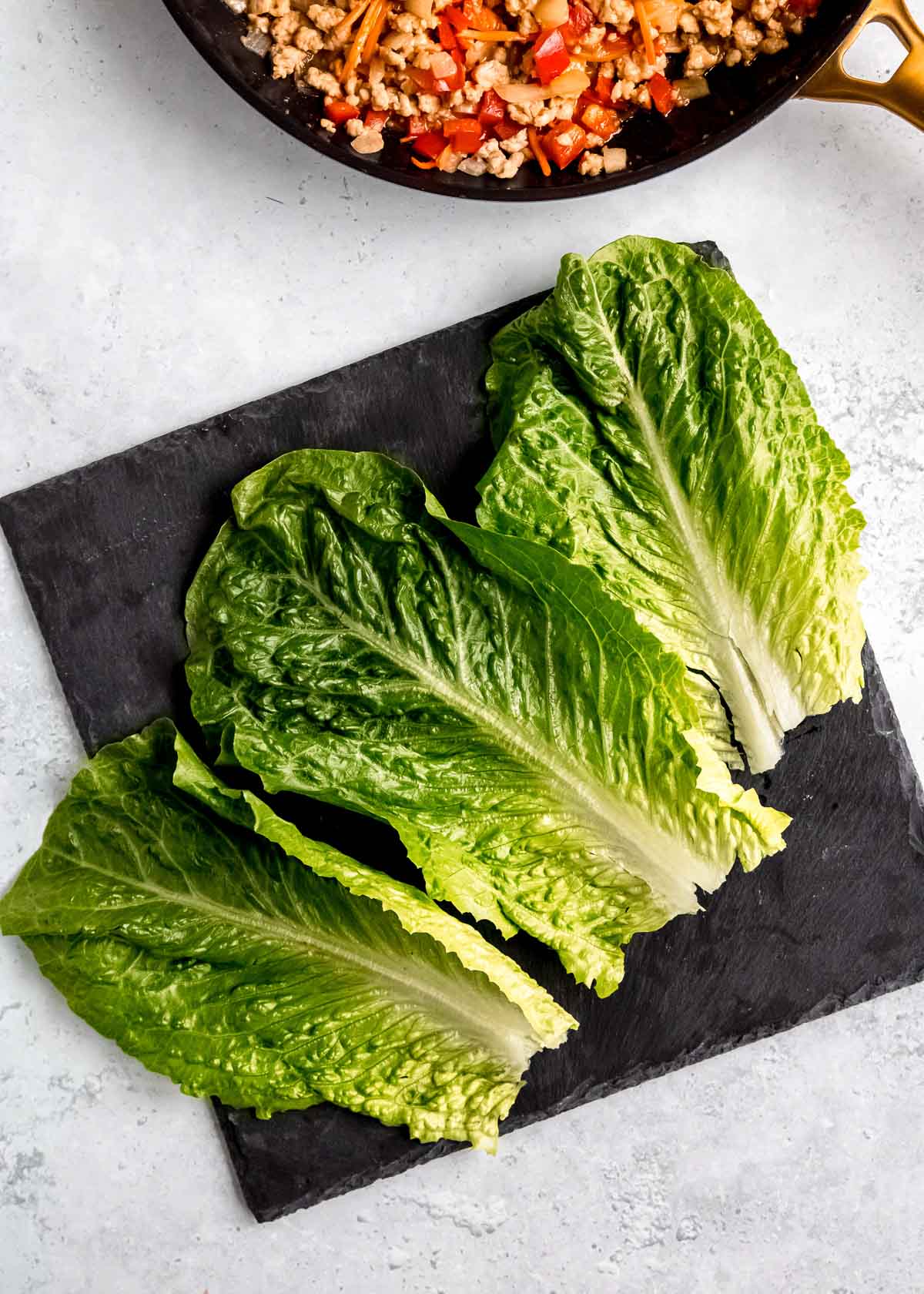 large romaine lettuce leaves on a cutting board