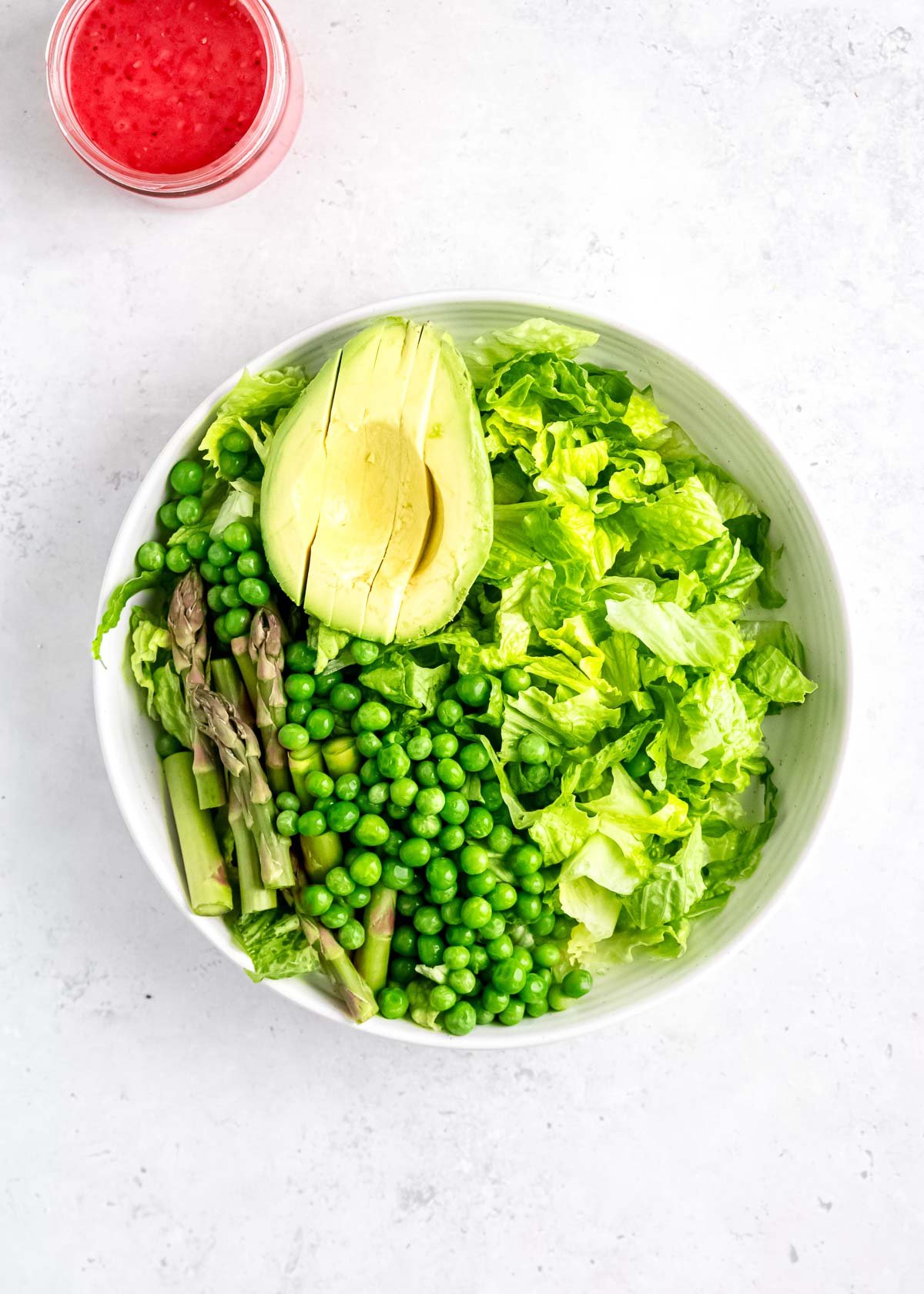 asparagus, avocado, peas, and lettuce in white bowl