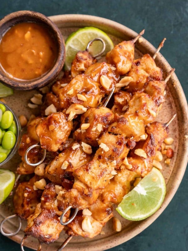 overhead image of thai chicken skewers on a brown plate