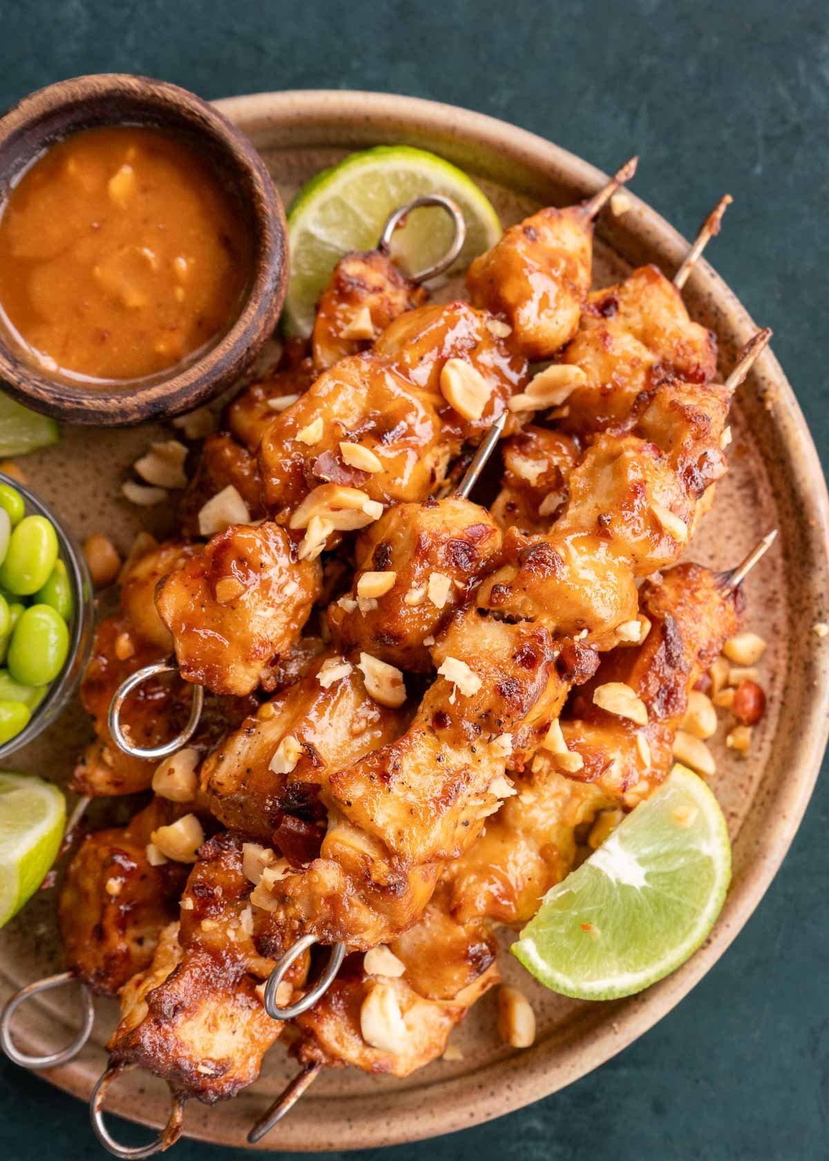 overhead image of thai chicken skewers on a brown plate