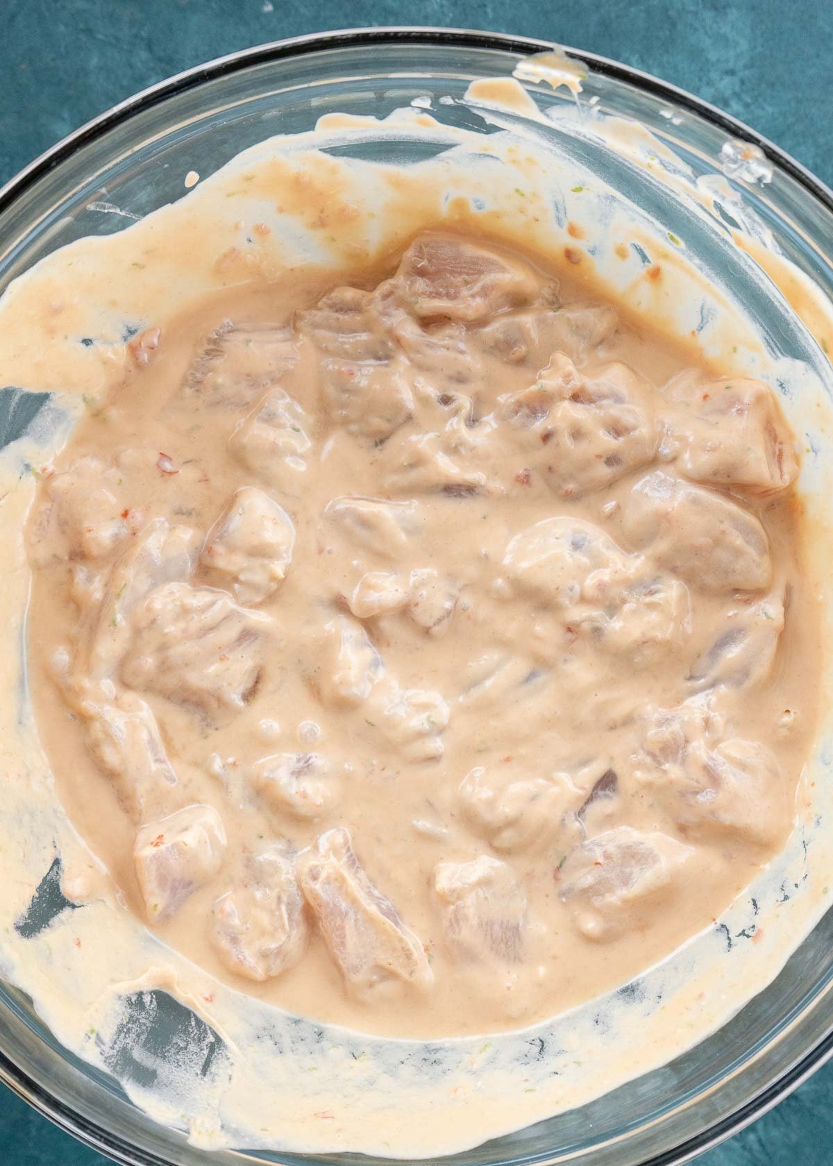 chicken being marinated in peanut sauce