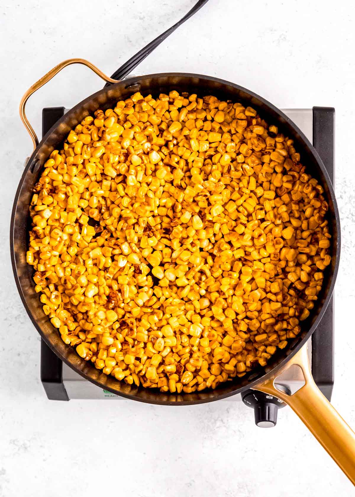 overhead image of corn being sauteed in skillet