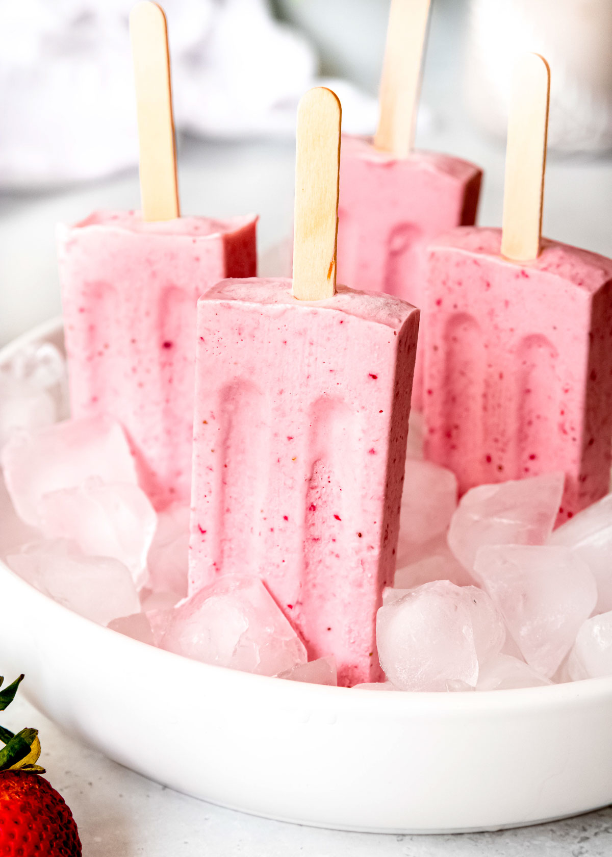strawberry ice cream bars in a bowl of ice