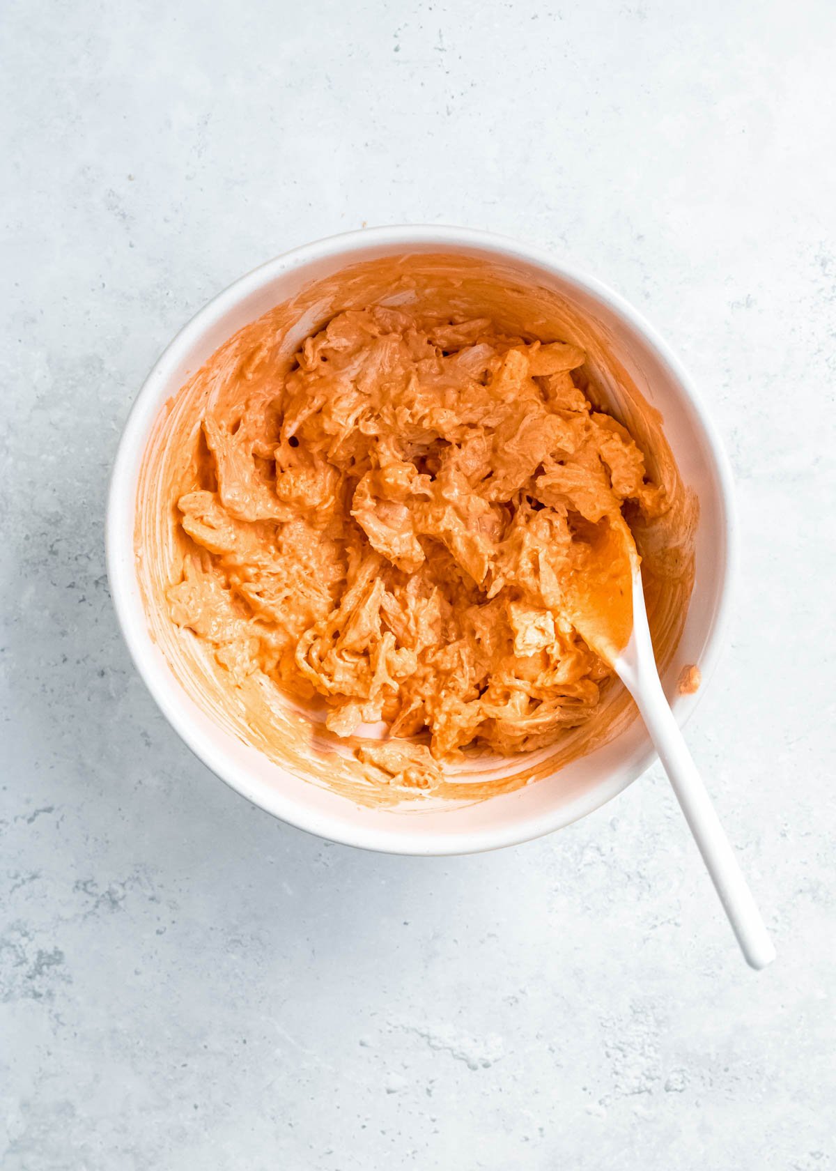 a white bowl filled with creamy buffalo chicken