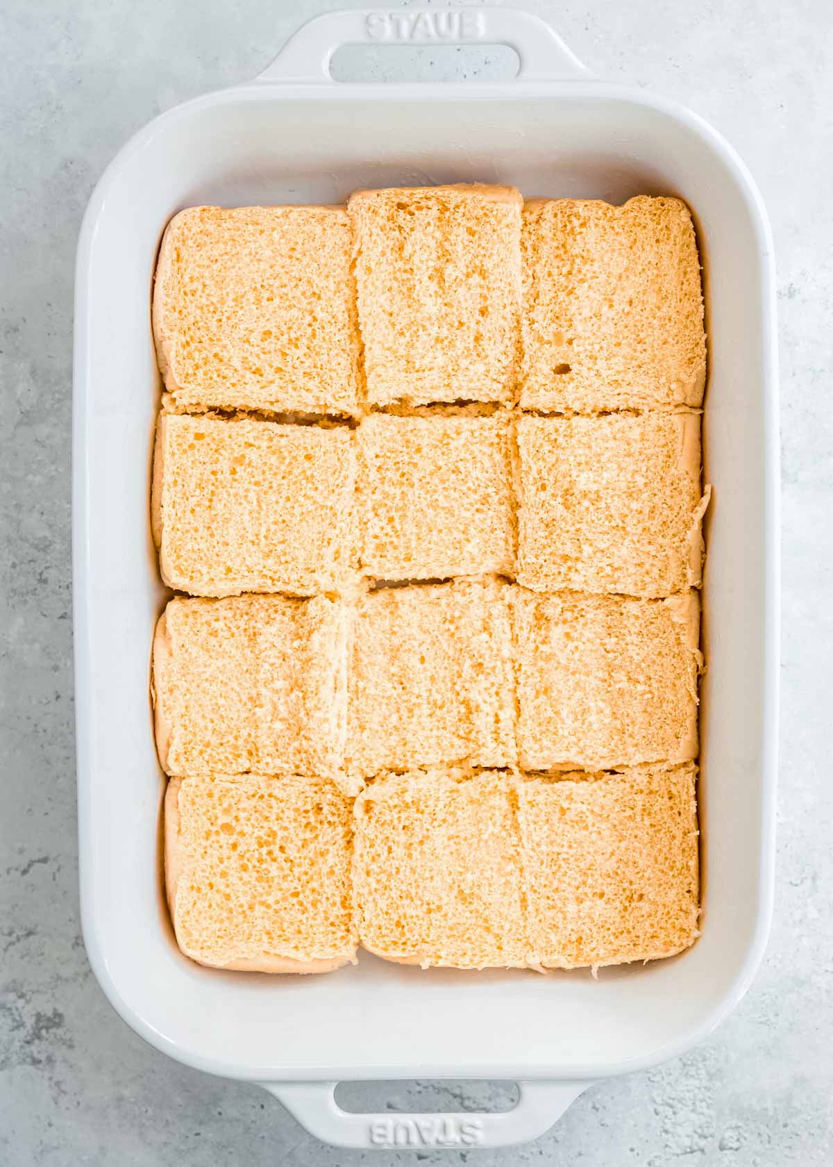 bottom buns situated in a white casserole dish