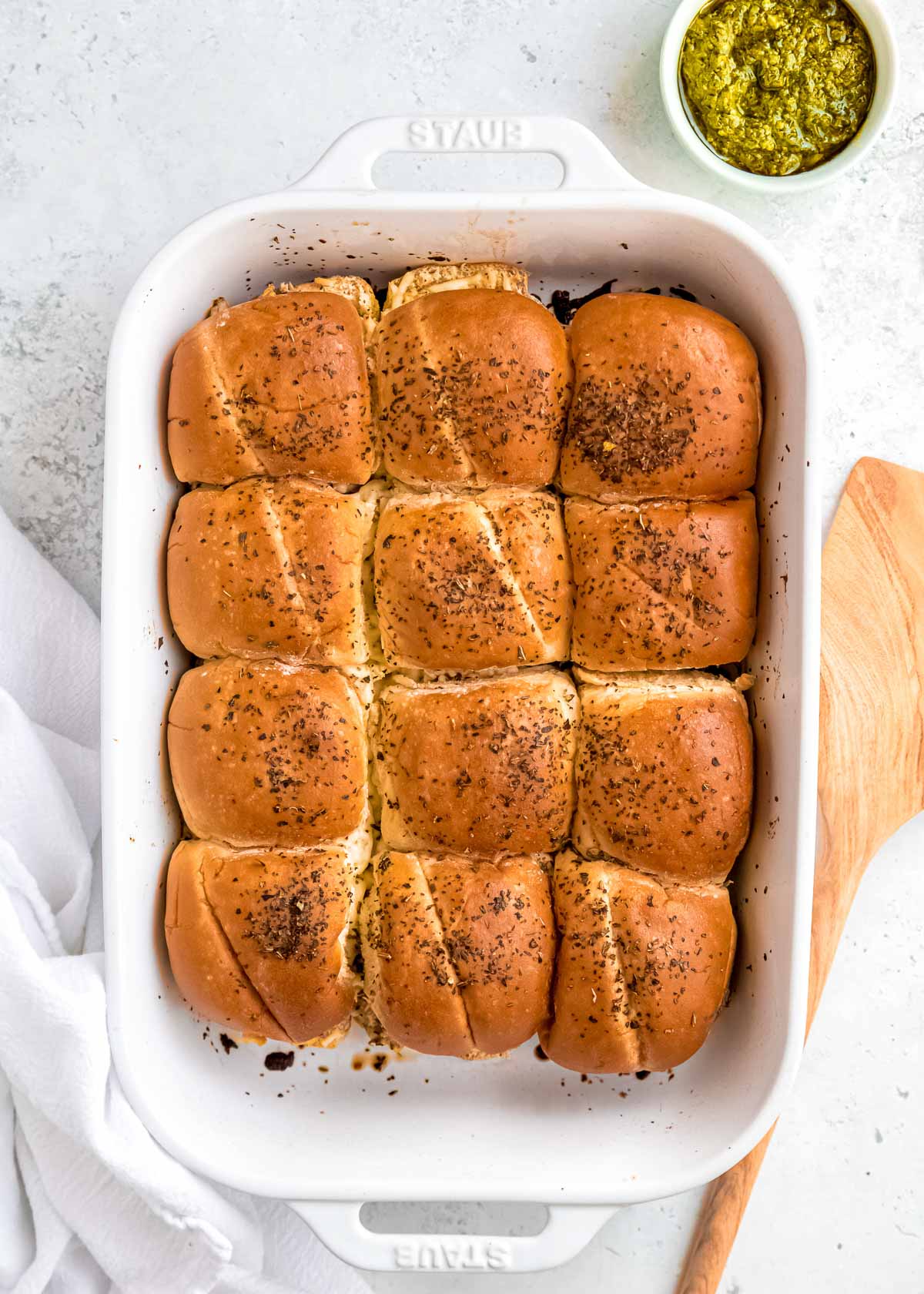 baked cheesy pesto chicken sliders topped with herbs