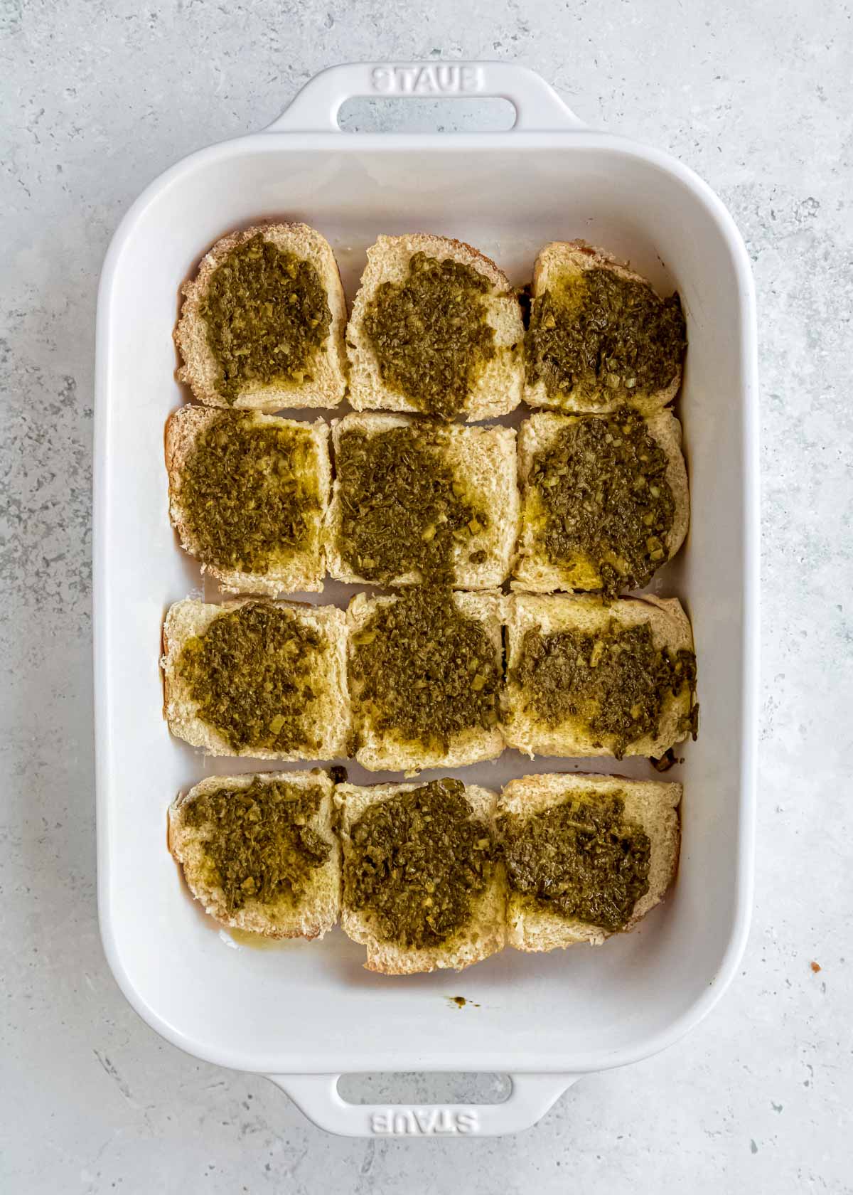 pesto sauce on rolls in a baking dish